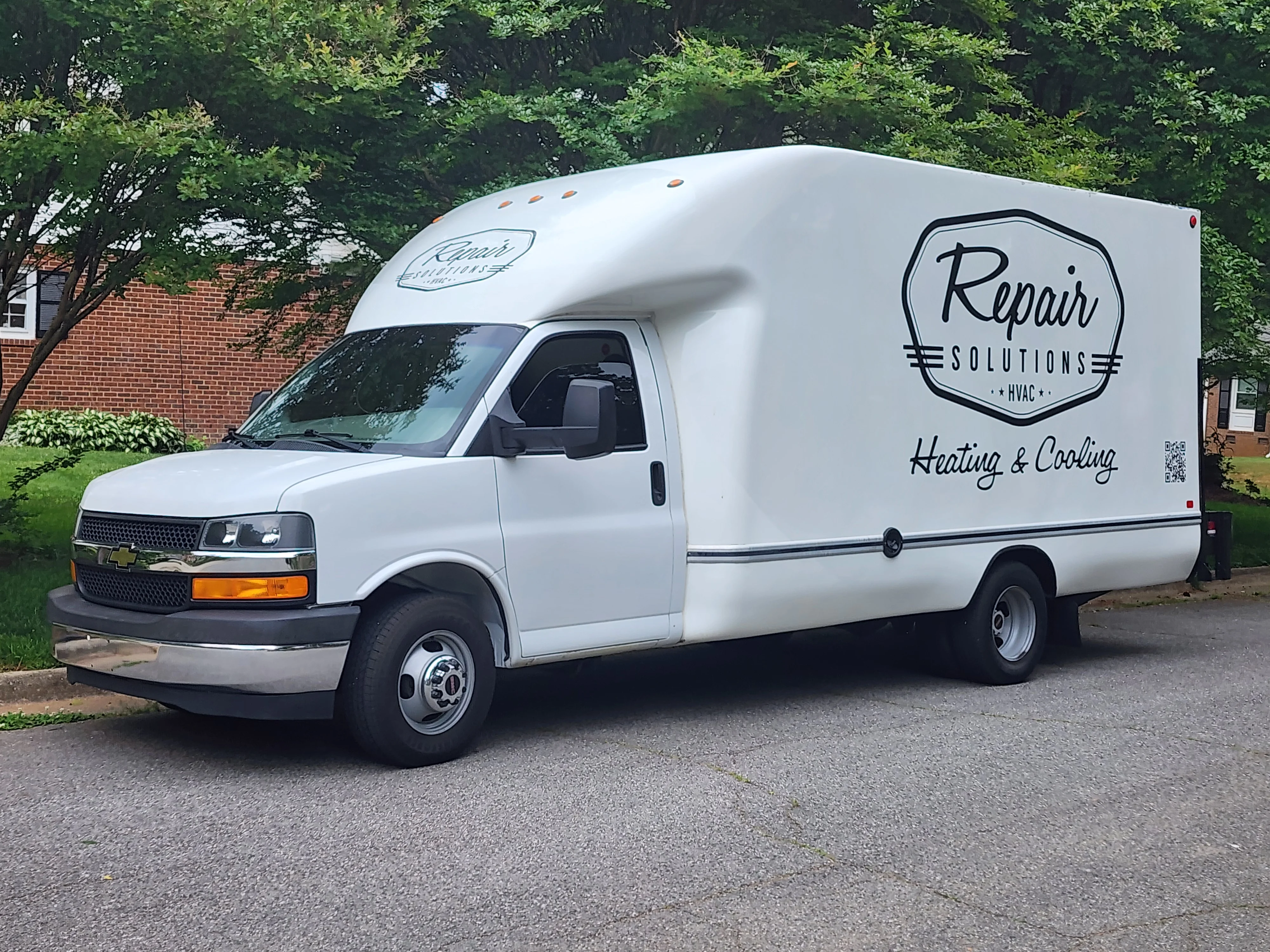 White service van with custom vinyl wrap displaying HVAC company branding and logo