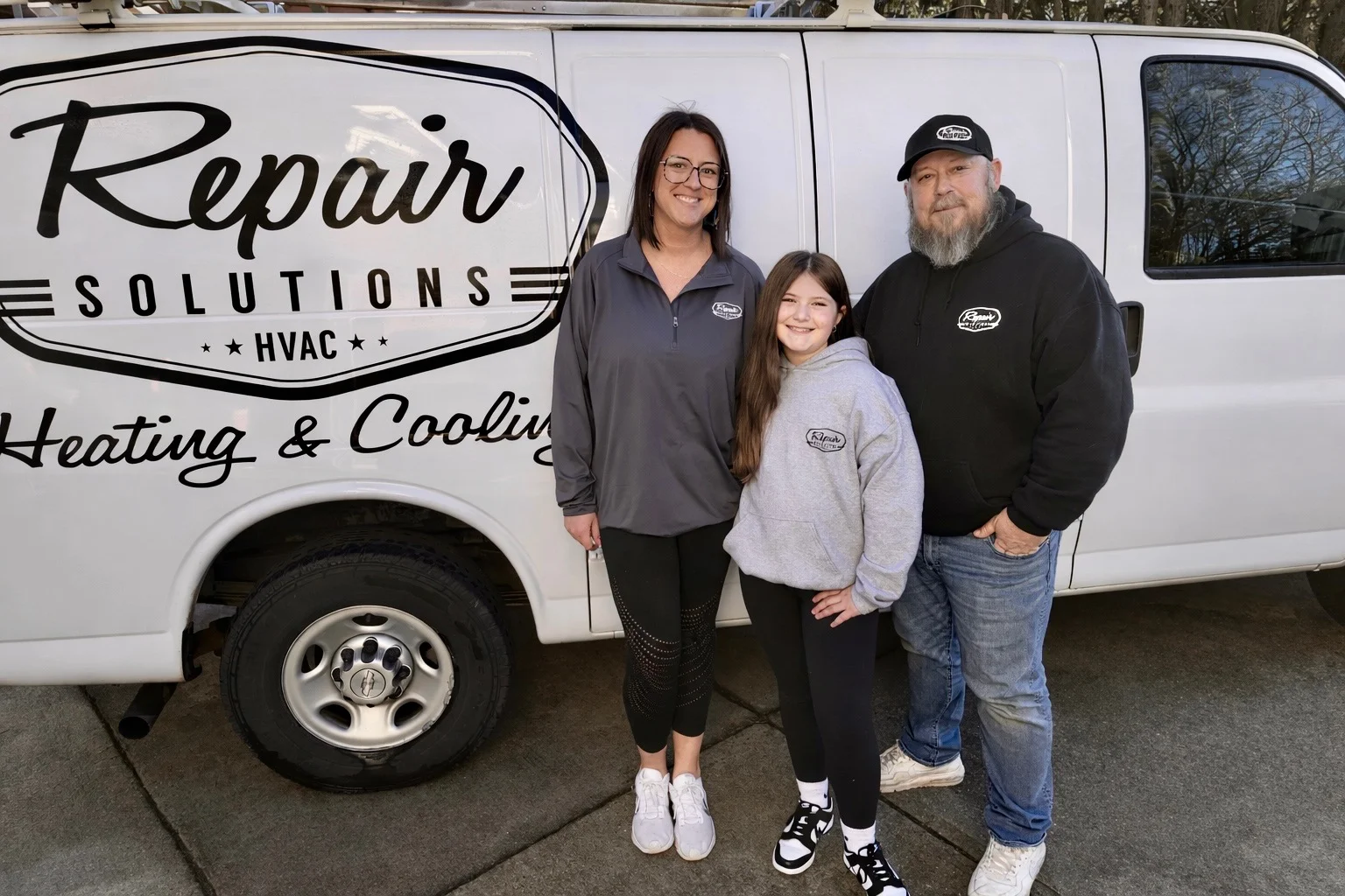 HVAC service team standing in front of white service van with company branding